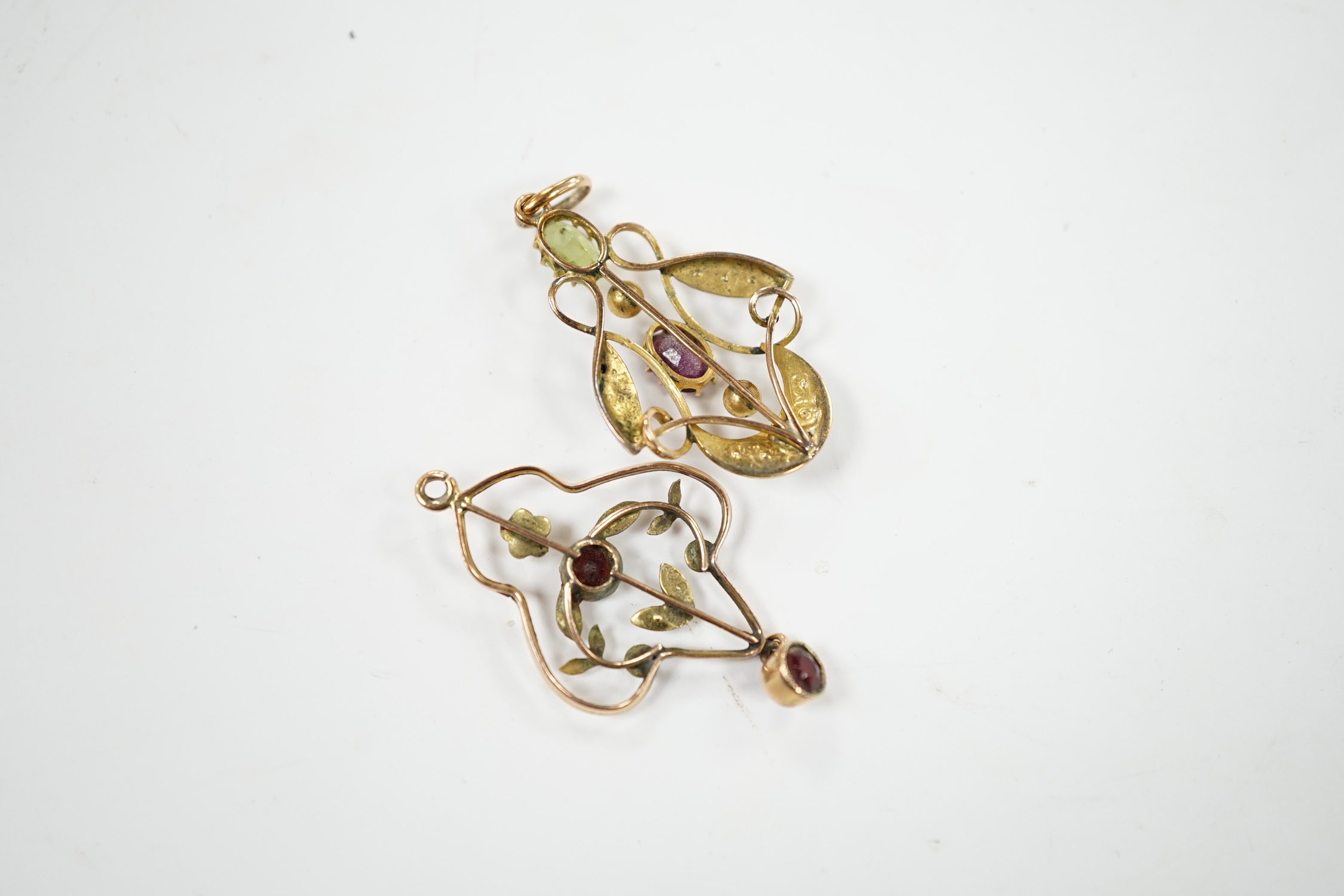 An early 20th century 9ct , peridot, garnet and seed pearl set cluster pendant, in the Suffragette colours, 32mm and one other yellow metal and gem set pendant.